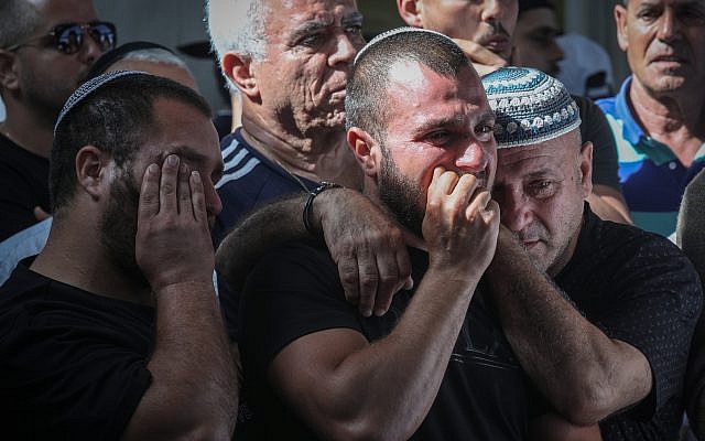 在家中被炸死的以色列公民摩西阿加迪的親友悲傷地參加他的葬禮。