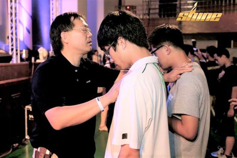 SHINE營會中，陳榮敏牧師為年輕人禱告