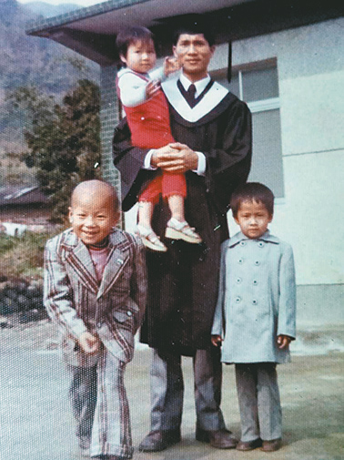 李義三牧師著畢業袍與三個孩子