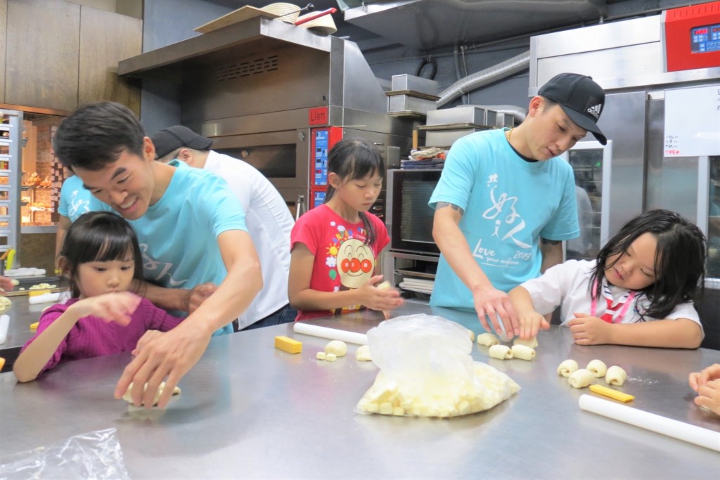 台北市99幸福甜烘焙坊，師傅下班後跟著老闆一起做愛心，帶領社區孩子DIY手作起司餐包，作為義賣品。