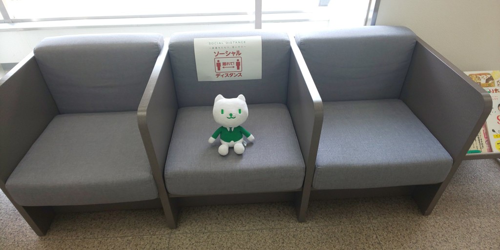銀行將貓咪吉祥物玩偶放在多人座沙發的中間座位，提醒顧客保持社交距離。（圖／twitter@Jえいどりあん ） 