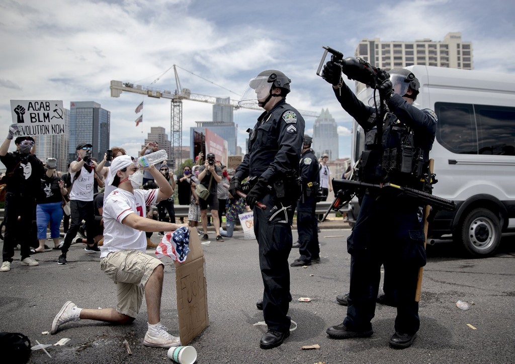 在德州奥斯汀，被警察噴辣椒水後，民眾用水洗眼睛。（圖／twitter@WagsPhoto）