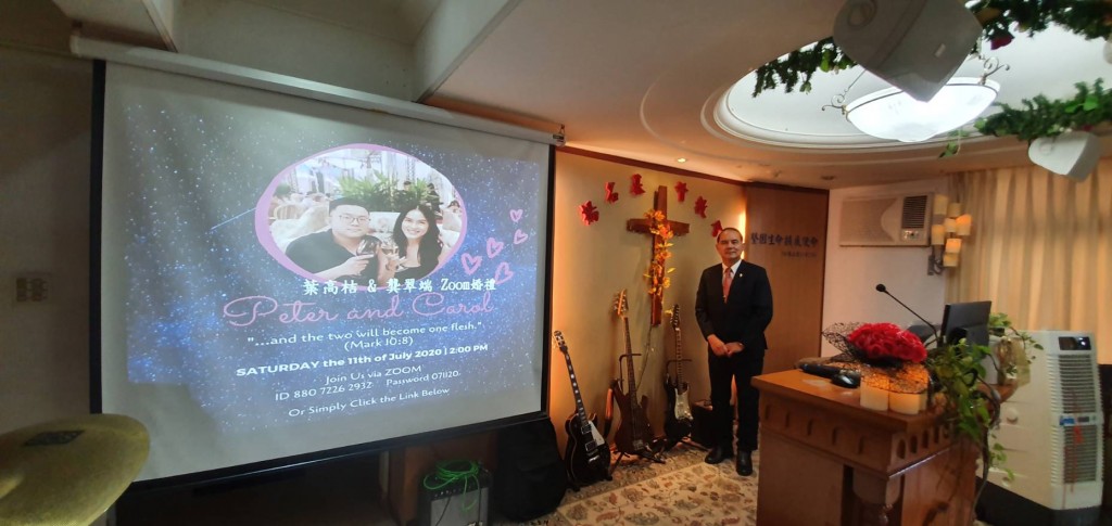 龔牧師夫婦在台灣穿上禮服，觀看網路直播見證女兒婚禮。（龔牧師提供）