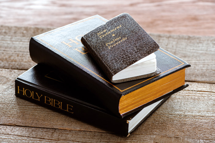 close-up shot of stacked holy bibles with new testament book on