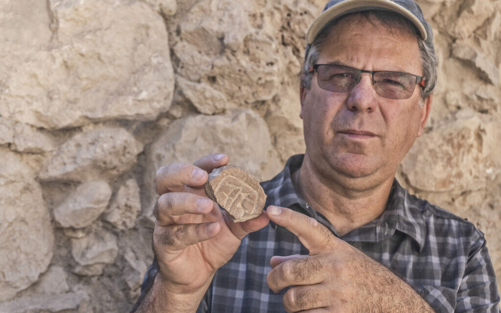 特拉維夫大學教授尤瓦爾．加朵特手上拿著在停車場挖掘出來的陶土印章碎片。（圖／Shai-Halevy-Israel Antiquities Authority）